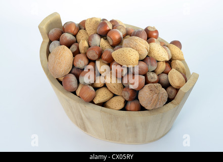 Noisettes, noix et amandes dans un panier en bois isolé sur fond blanc Banque D'Images