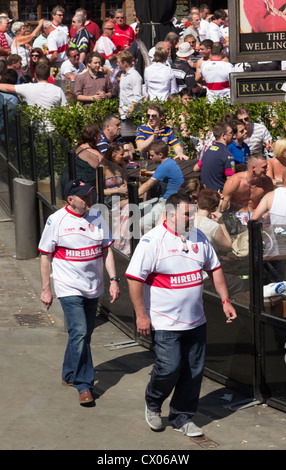 Deux Hull Kingston Rovers Rugby League Football club fans à pied passé dans les jardins de la bière pub Shambles Square, Manchester. Banque D'Images