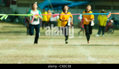 Trois fille enfant sprint à ligne d'arrivée dans le sport journée d'école en Thaïlande Banque D'Images