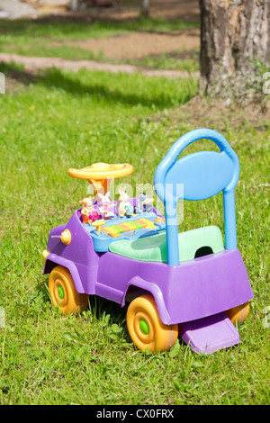 Jouet voiture enfant sur l'herbe dans la cour Banque D'Images