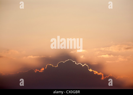 Doublure d'argent à mesure que le soleil disparaît derrière une ligne de nuages Banque D'Images