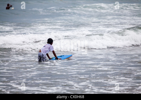 Surfer sur la plage de Kuta à Bali Banque D'Images