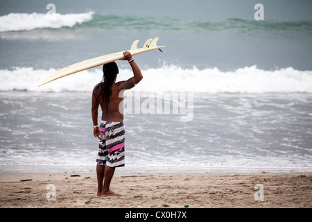 Surfer sur la plage de Kuta à Bali Banque D'Images