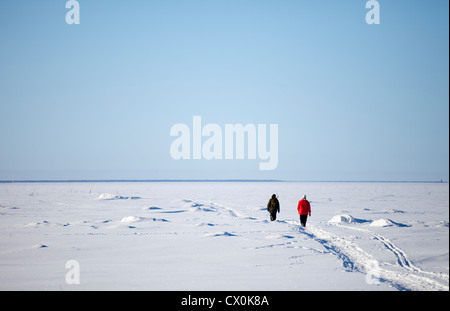 Deux pêcheurs à pied sur la glace de mer à Baie de Botnie , Finlande Banque D'Images