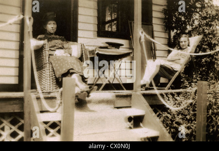 Deux femmes assis sur la véranda de leur maison d'été en vacances dans les années 1920, en Angleterre, UK. Banque D'Images
