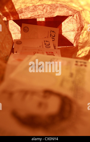 Sterling notes dans un sac en papier brun Banque D'Images