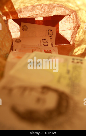 Sterling notes dans un sac en papier brun Banque D'Images