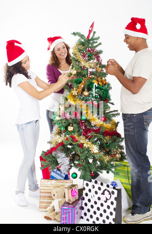 Heureux famille multiraciale decorating Christmas Tree Banque D'Images