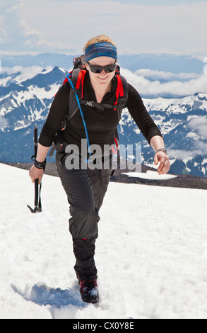 Une femme climber fait son chemin jusqu'à la neige Muir champ sur le Mont Rainier, Washington State, USA. Banque D'Images