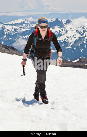 Une femme climber fait son chemin jusqu'à la neige Muir champ sur le Mont Rainier, Washington State, USA. Banque D'Images