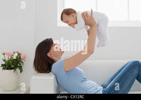 Mère soulevant baby girl Banque D'Images