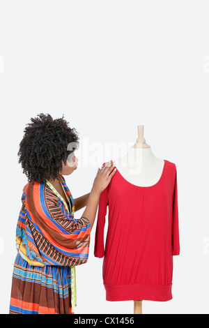 African American female fashion designer à la tunique rouge à plus de fond gris Banque D'Images