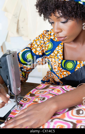 African American female adapter tissu à motifs de couture sur machine à coudre Banque D'Images