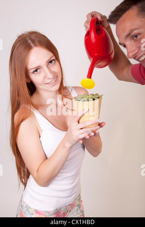 Portrait d'un jeune couple heureux fleur d'arrosage. Banque D'Images