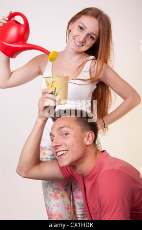 Portrait d'un jeune couple heureux fleur d'arrosage. Banque D'Images