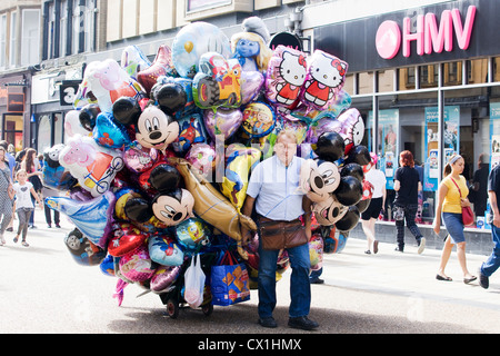 L'homme tirant le long de ballons pour vendre à Oxford en Angleterre Banque D'Images