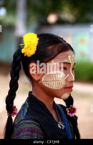 Jeune fille avec un birman tanaka visage peint. Cette crème d'un arbre est considéré comme bon et protéger la peau du soleil.utilisé principalement des femelles. Banque D'Images