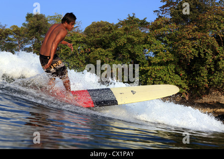 Surf surfeur local point l'onde de rupture sur un longboard à Batu Karas dans l'Ouest de Java. Banque D'Images