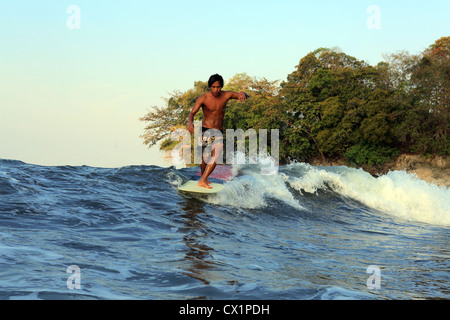 Surf surfeur local point l'onde de rupture sur un longboard à Batu Karas dans l'Ouest de Java. Banque D'Images