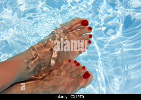 Femme de détente avec son pied sur l'eau Banque D'Images