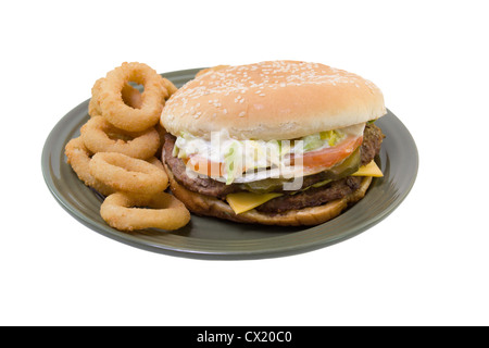Pile double cheeseburger avec tomate, laitue, oignons, mayo, cornichons et oignons sur une plaque verte isolated on white Banque D'Images