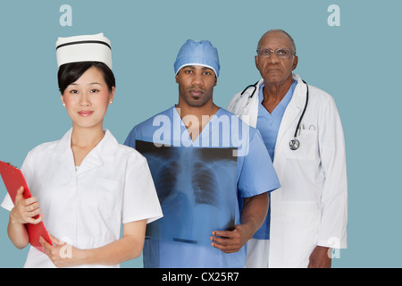 Portrait de trois professionnels médicaux multi ethnic sur fond bleu clair Banque D'Images