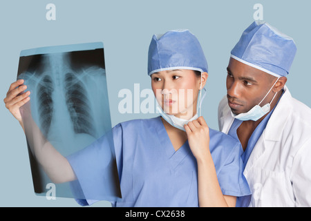 Deux surgeons examining x-ray rapport sur fond bleu clair Banque D'Images