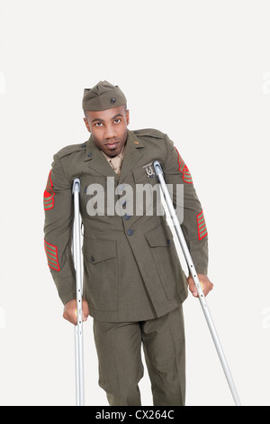 Portrait d'un officier de l'armée US avec des béquilles sur fond gris Banque D'Images