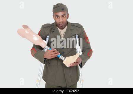 Portrait d'un officier militaire US handicapés prothèse holding jambe sur fond gris Banque D'Images