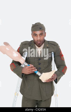Portrait d'un officier militaire US handicapés prothèse holding jambe sur fond gris Banque D'Images