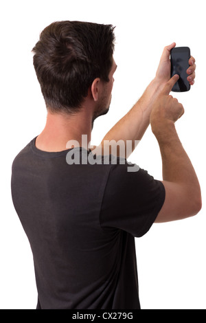 Jeune homme blanc en noir T-Shirt travaillant sur son smartphone Banque D'Images