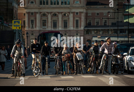 Les navetteurs sur les bicyclettes en attente de feu vert dans la vieille ville de Gamla Stan à Stockholm en Suède avec l'Opéra en arrière-plan Banque D'Images