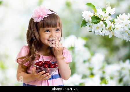 Petite fille aux petits fruits cerise bol en studio isolated Banque D'Images