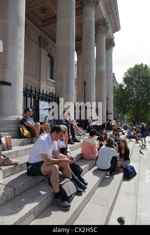 Les touristes en appui sur les mesures à l'extérieur de St Martins dans l'église de champs à Londres Banque D'Images