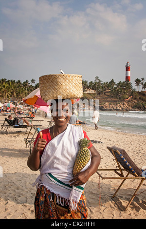 Kovallam beach, femmes vendant ananas, phare, l'Inde Kerala Banque D'Images