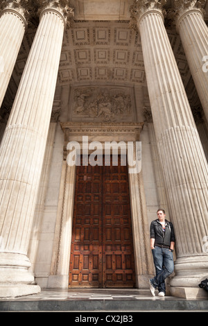 L'homme appuyé contre une des colonnes à l'entrée de Saint Pauls Cathedral à Londres Banque D'Images