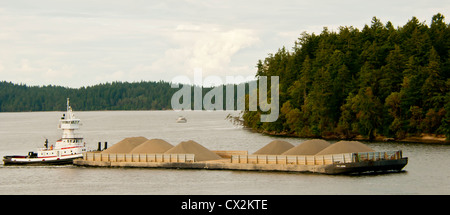 Remorqueur Bateau poussant grande barge de gravier le long du littoral de la région de Puget Sound, Washington Banque D'Images