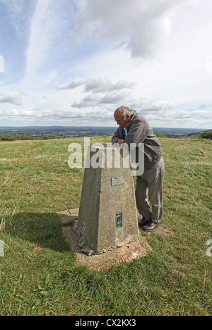 Homme lisant l'information sur le socle en pierre en haut de Ditchling Beacon, East Sussex. Banque D'Images