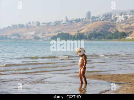 Enfant sur la rive du lac de Tibériade près de la ville de Tibériade, à l'été le matin Banque D'Images