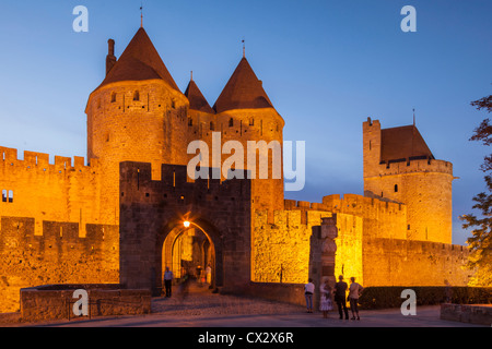 La Porte narbonnaise, l'entrée principale de l'ancienne ville fortifiée de Carcassonne, illuminée le soir. Banque D'Images
