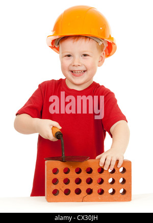 Boy in hard hat avec truelle et isolés en brique Banque D'Images