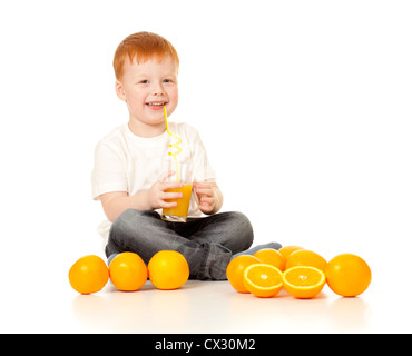 Garçon roux avec jus ornage et oranges isolated on white Banque D'Images