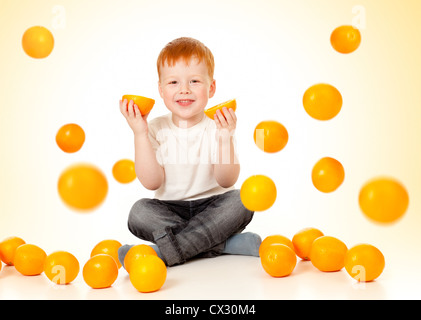 Garçon roux avec la chute des oranges Banque D'Images