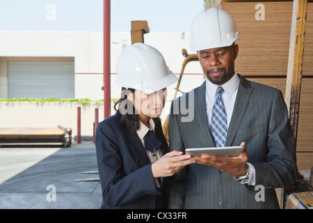 Les entrepreneurs multiethnique à l'aide de Tablet PC à timber yard Banque D'Images