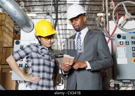 Mâle et femelle travailleur industriel Ingénieur en discussion à l'usine de bois Banque D'Images