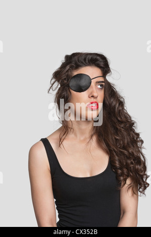 Young woman wearing eye patch sur fond gris Banque D'Images