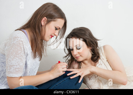 Young woman applying nail peinture aux ongles de votre ami Banque D'Images