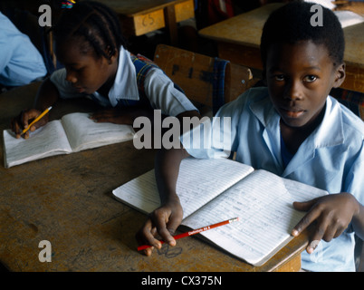 St Kitts Basseterre École Beechwood Enfants en classe Garçon et fille avec les livres d'exercice Banque D'Images