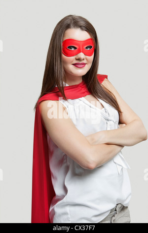 Portrait d'une jeune femme en costume de super-héros sur fond gris Banque D'Images