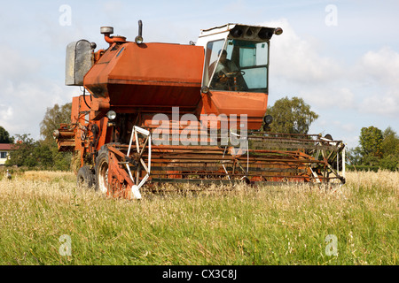 Vieux grain harvester travaillant sur terrain Banque D'Images